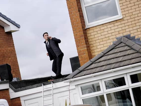 Matt Ashton singing on his garage roof