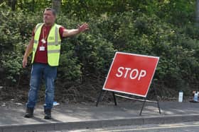 A council employee directs traffic at the recycling centre in Ince