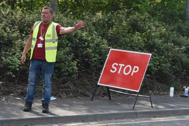 A council employee directs traffic at the recycling centre in Ince
