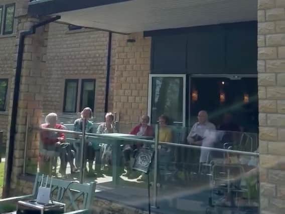 Residents enjoy the concert from their patio