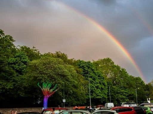 A rainbow sits over the newly illuminated Tree of Hope