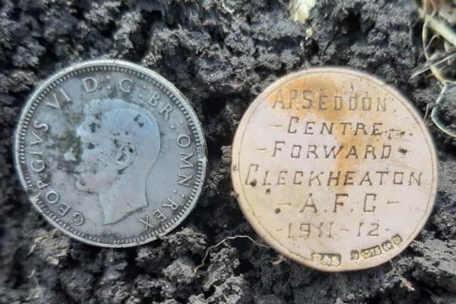 The football medal, right, and a coin found by Scott