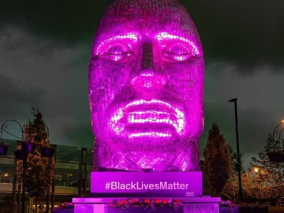 The Face of Wigan lit up purple