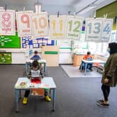 Children and teacher maintain social distancing measures while they take part in lessons
