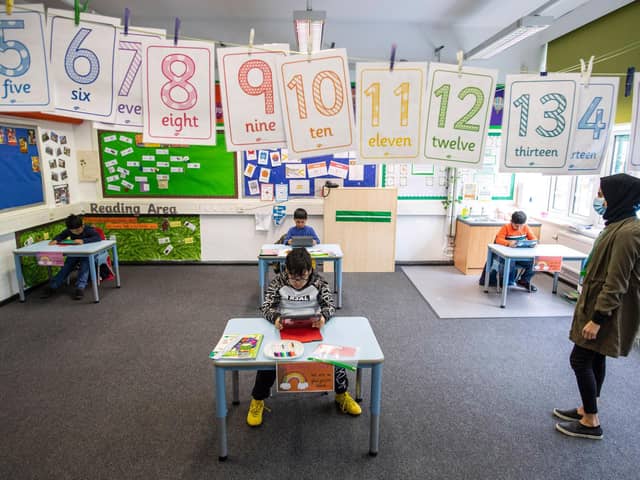 Children and teacher maintain social distancing measures while they take part in lessons