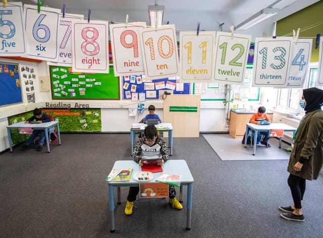 Children and teacher maintain social distancing measures while they take part in lessons