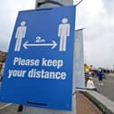 Signs ask visitors to adhere to the British government's current social distancing guidelines and stay two meters apart