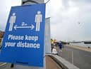Signs ask visitors to adhere to the British government's current social distancing guidelines and stay two meters apart