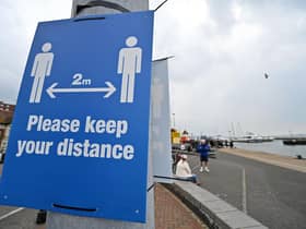 Signs ask visitors to adhere to the British government's current social distancing guidelines and stay two meters apart