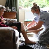 A nurse wearing PPE carrying out a home visit