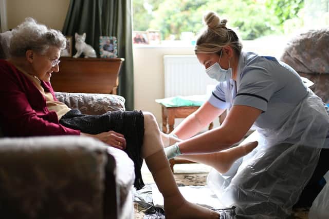 A nurse wearing PPE carrying out a home visit