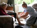A nurse wearing PPE carrying out a home visit