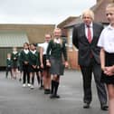 Prime Minister Boris Johnson waits in line in the playground to wash his hands during a visit to Bovingdon Primary School in Bovingdon, Hemel Hempstead, Hertfordshire