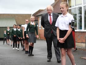 Prime Minister Boris Johnson waits in line in the playground to wash his hands during a visit to Bovingdon Primary School in Bovingdon, Hemel Hempstead, Hertfordshire