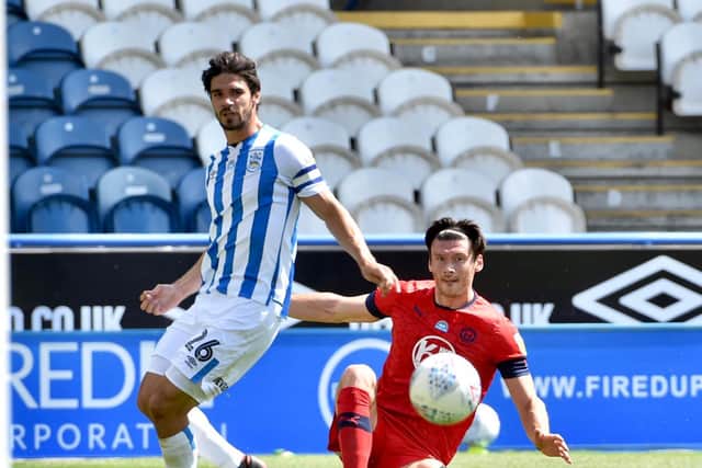 Wigan's Kieffer Moore in the thick of the action with Huddersfield's Christopher Schindler