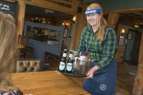 Beer being served by a bartender wearing PPE. Picture by PA