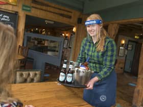 Beer being served by a bartender wearing PPE. Picture by PA