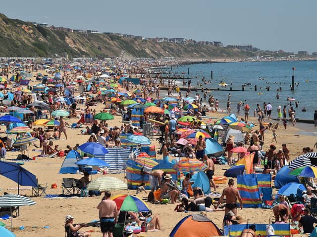 Beachgoers enjoy the sunshine as they sunbathe and play in the sea on Boscombe beach in Bournemouth (Photo by GLYN KIRK/AFP via Getty Images)