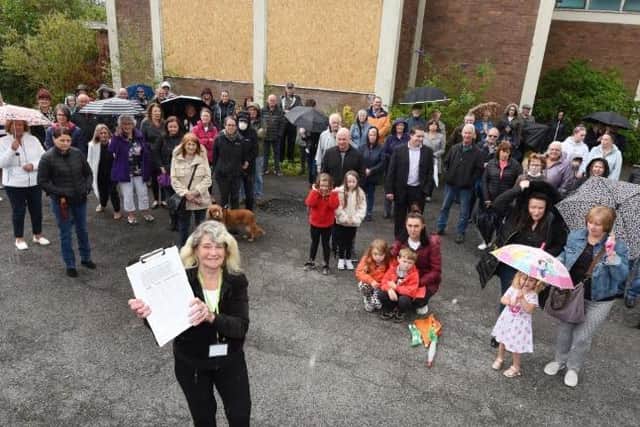 Bryn ward councillors Sylvia Wilkinson (front with the petition) and Steve Jones with local residents, who are protesting about the planning application on the land of Bryn St Peter's church currently stands.
