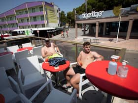 Two tourists sit at a bar on Punta Ballena street in Magaluf on the Spanish island of Mallorca  (Photo by JAIME REINA/AFP via Getty Images)