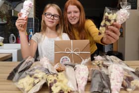 Ava Brittain, nine, and sister Freya Southworth, 13, have been making treats including chocolate and popcorn for gifts with, inset, one of the popcorn post boxes