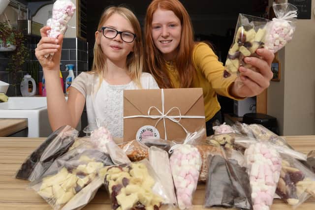 Ava Brittain, nine, and sister Freya Southworth, 13, have been making treats including chocolate and popcorn for gifts with, inset, one of the popcorn post boxes