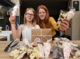 Ava Brittain, nine, and sister Freya Southworth, 13, have been making treats including chocolate and popcorn for gifts with, inset, one of the popcorn post boxes