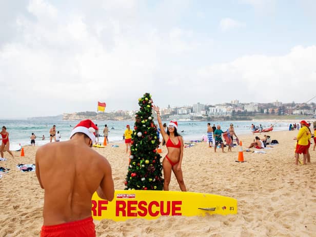 Italians pose for a photograph in front of a Christmas tree at Bondi Beach on December 25, 2019 in Sydney, Australia