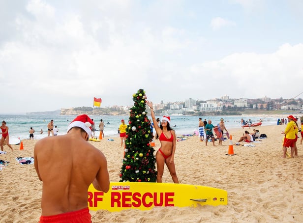 Italians pose for a photograph in front of a Christmas tree at Bondi Beach on December 25, 2019 in Sydney, Australia