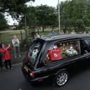 People line the streets as the funeral cortege of Jack Charlton passes through his hometown of Ashington, in Northumberland