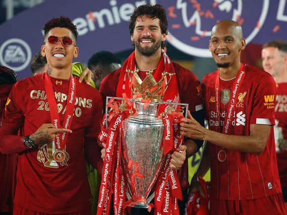 Fabinho (right) poses with the Premier League trophy with Liverpool teammates   Roberto Firmino and Alisson Beckerduring the  trophy presentation at Anfield.