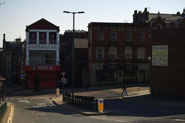 A pedestrian walks in a quiet street in Oldham