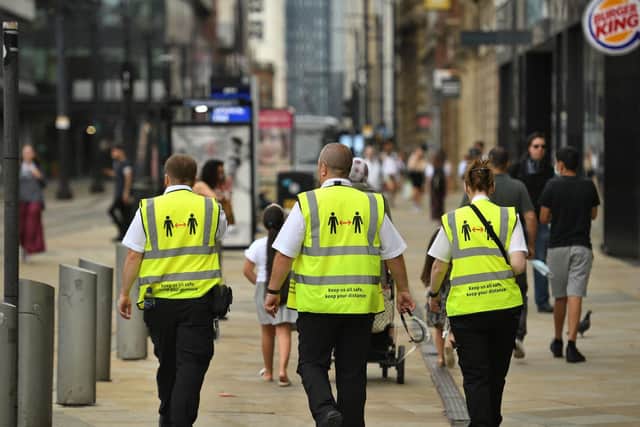 Metrolink workers wear high vis jackets with that urge social distancing as a precuation against the transmission of the novel coronavirus in Manchester (Photo by OLI SCARFF/AFP via Getty Images)