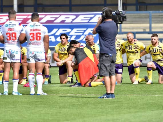 Bevan French and David Fifita took a knee with the Aboriginal Australian flag draped over their backs