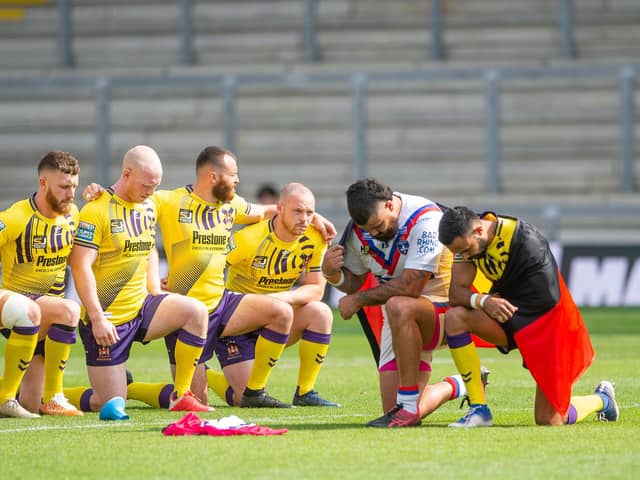 Bevan French and Wakefield's David Fifita take the knee with the Australian Aboriginal flag draped over their backs on Sunday