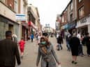 Pedestrians wear facemasks as they walk through a pedestriansed street in Oldham, Greater Manchester (Photo by OLI SCARFF/AFP via Getty Images)