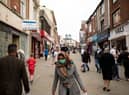 Pedestrians wear facemasks as they walk through a pedestriansed street in Oldham, Greater Manchester (Photo by OLI SCARFF/AFP via Getty Images)