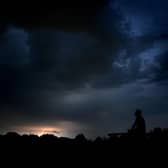 A man watches Monday night's thunderstorm from Buckshaw Village in Lancashire