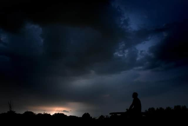 A man watches Monday night's thunderstorm from Buckshaw Village in Lancashire