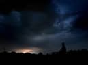 A man watches Monday night's thunderstorm from Buckshaw Village in Lancashire