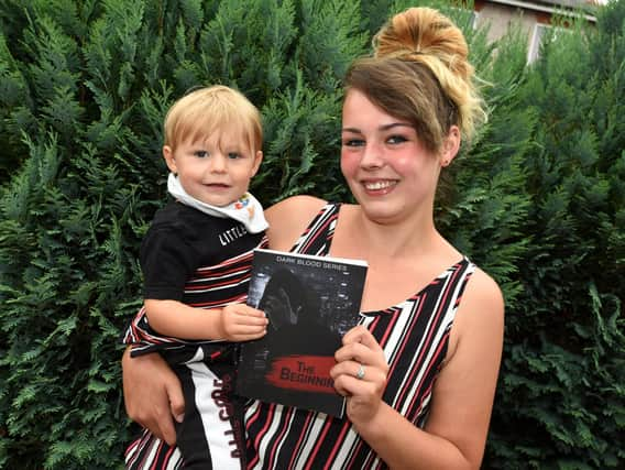 Taylor and son Levi with the book