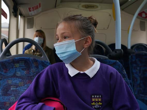 A pupil wearing a mask on a bus