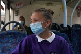 A school pupil wearing a face mask on a bus