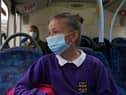 A school pupil wearing a face mask on a bus