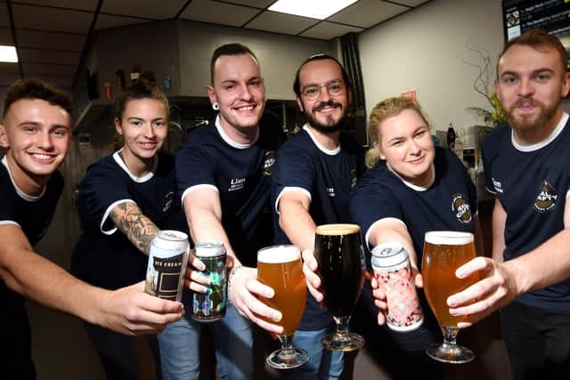 Staff at Real Crafty raise a beer to the opening of the new venue