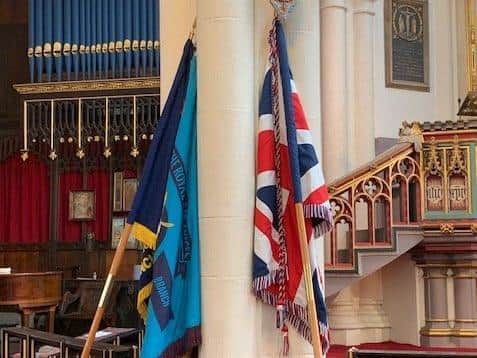 The RAF branch standard and Union Flag at Wigan Parish Church's 80th anniversary service for the Battle of Britain