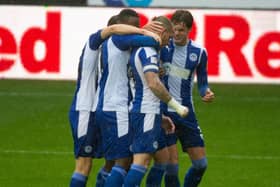 Joe Garner is mobbed after his winning goal