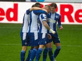 Joe Garner is mobbed after his winning goal