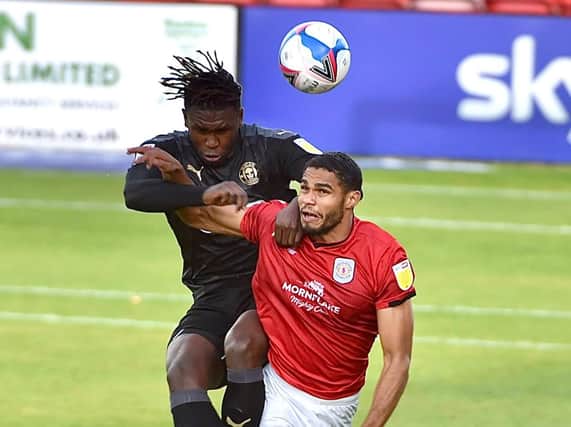 Darnell Johnson competes for the ball with ex-Latics striker Mikael Mandron