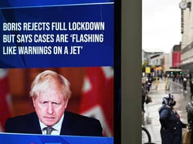 A news display features Britain's Prime Minister Boris Johnson as shoppers make their way along the streets of Manchester